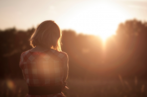 Standing in nice dress staring at the sunset.